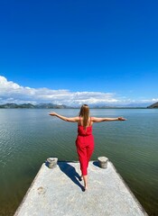 Young girl in a trendy red clothes enjoying the beauty of nature, relaxing, adventure, amazing nature, tour agency concept.