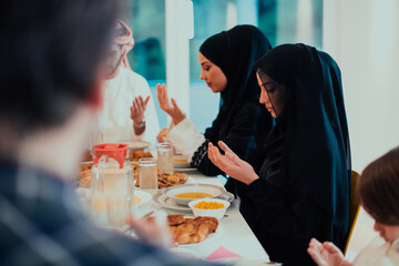 A Muslim family praying together, the Muslim prayer after breaking the fast in the Islamic holy month of Ramadan