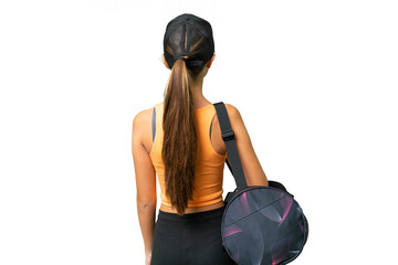 Teenager caucasian girl with sport bag over isolated background in back position