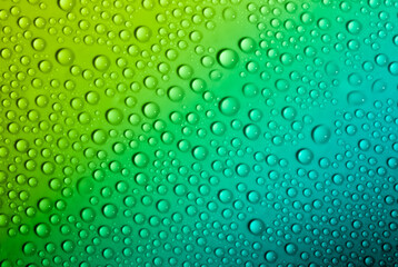 Fototapeta na wymiar Water drops on glass as a background. Condensation on a cold drink. Green background with drops texture.