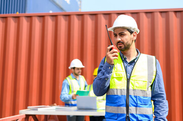container operators wearing helmets and safety, vests control via walkie-talkie workers in...