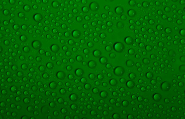 Naklejka na ściany i meble Water drops on glass as a background. Condensation on a cold drink. Green background with drops texture.