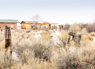 Abandoned adobe, yellow with painting, Costilla, NM, winter with snow
