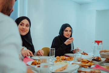  Muslim family having Iftar dinner drinking water to break feast. Eating traditional food during Ramadan feasting month at home. The Islamic Halal Eating and Drinking in modern home 