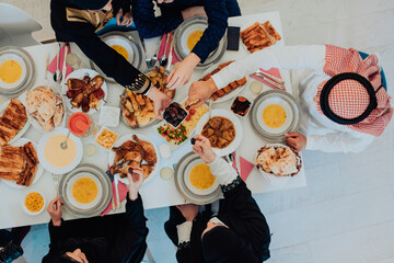  Muslim family having Iftar dinner drinking water to break feast. Eating traditional food during Ramadan feasting month at home. The Islamic Halal Eating and Drinking in modern home 