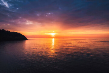 Beautiful sunset over tropical sea with tourists rowing canoe and enjoy the view in summer