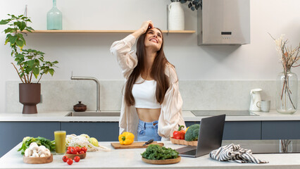 A joyful brunette woman prepares a salad of fresh vegetables 
