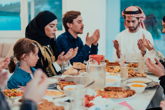 A Muslim family praying together, the Muslim prayer after breaking the fast in the Islamic holy month of Ramadan