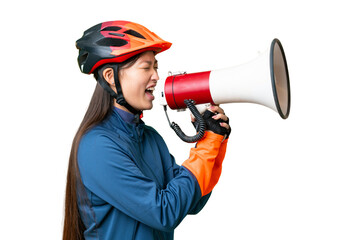 Young cyclist woman over isolated chroma key background shouting through a megaphone - obrazy, fototapety, plakaty