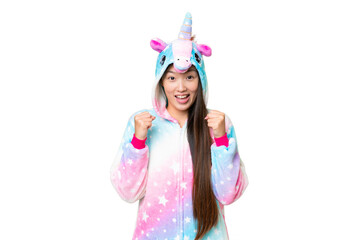 Young Asian woman with unicorn pajamas over isolated chroma key background celebrating a victory in winner position