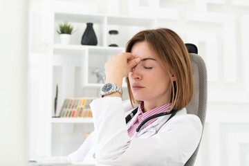 Close up portrait of shocked female doctor sitting at the desktop and working in the office of modern clinic