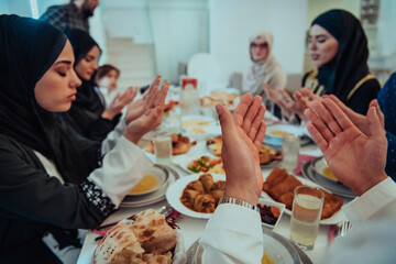 A Muslim family praying together, the Muslim prayer after breaking the fast in the Islamic holy month of Ramadan
