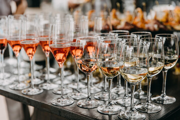 Glasses of champagne and wine on a table at a fourchette at a party.
