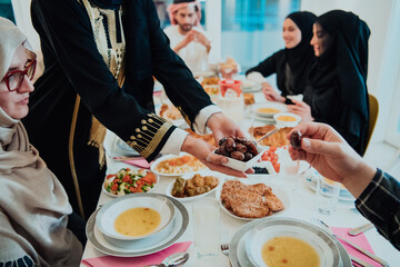  Muslim family having Iftar dinner drinking water to break feast. Eating traditional food during Ramadan feasting month at home. The Islamic Halal Eating and Drinking in modern home 
