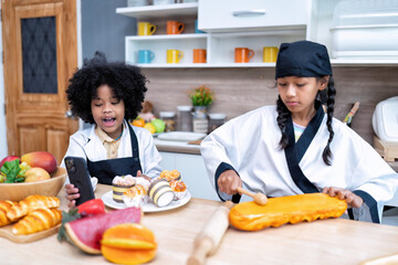 Children in learning kitchen room use mobile phone video call learn sell bread on line