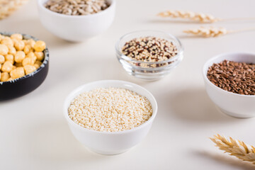 Sesame seeds in a bowl and other seeds in bowls on the table. Healthy food.