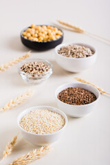 Sesame, flax seeds, quinoa, sunflower seeds and chickpeas in bowls. Healthy food. Vertical view