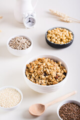 Obraz na płótnie Canvas Dry granola, sesame seeds, flax seeds, sunflower seeds, chickpeas and quinoa in bowls. Vertical