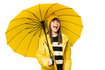 Little girl with rainproof coat and umbrella over isolated chroma key background laughing