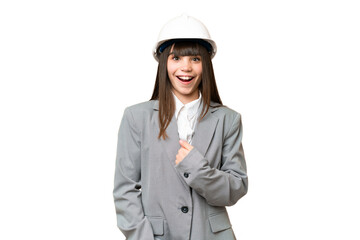 Little girl playing as a architect with helmet and holding blueprints over isolated background with surprise facial expression