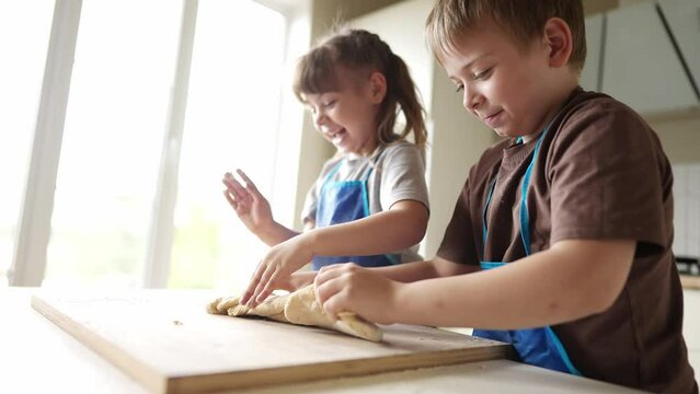 children kids making dough in the kitchen. baby boy cook in the kitchen knead dough and flour lifestyle indoors. happy family kid dream concept. children bake play cooking dough together at home