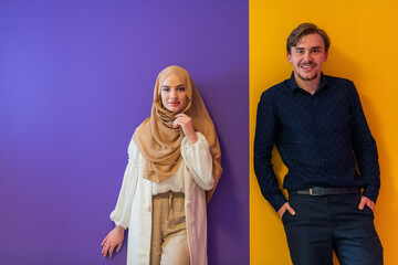 Fototapeta premium Portrait of young muslim couple woman in fashionable dress with hijab isolated on colorful background representing modern islam fashion and ramadan kareem concept