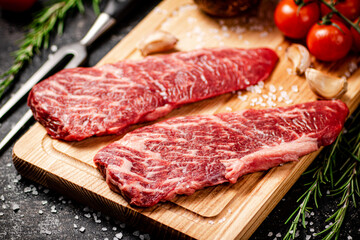 Raw steak on a wooden cutting board. 