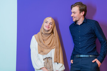 Portrait of happy young muslim couple standing isolated on colorful background