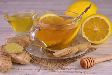 Ginger tea with lemon and honey in a transparent cup.

