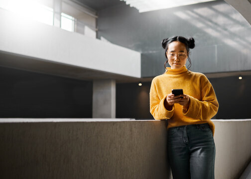 Woman, Phone And Texting In Office Building, Relax And Calm While On Internet, Search And Reading. Asian, Girl And Business Entrepreneur With Smartphone For Research, Office Space Or Idea In Japan