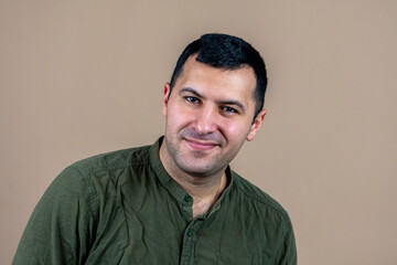 Fototapeta premium Portrait of a happy man 30-35 years old on a light pink background.