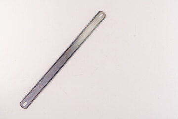 Top view of hacksaw blade isolated on white background with empty text area.