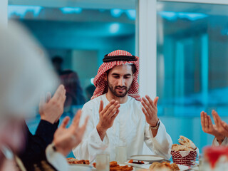 A Muslim family praying together, the Muslim prayer after breaking the fast in the Islamic holy month of Ramadan