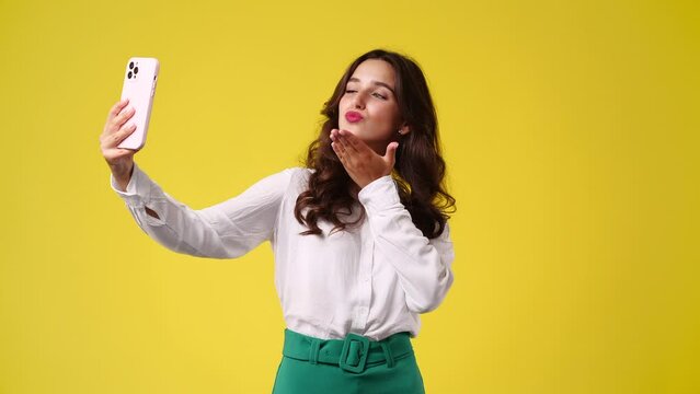 4k slow motion video of beautiful girl making selfie on yellow background.