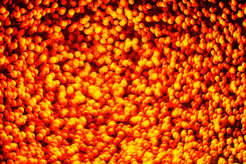 Golden shiny background. Abstract vibrant color glowing white spots texture for graphic design. Bright yellow defocused glitter texture. Fire sparkles background.