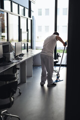 Young man with down syndrome working in a hospital as cleaner. Concpet of integration people with...