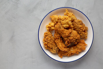 Chicken Popcorn, Wings and Tenders with BBQ Sauce on a plate on a gray background, top view. Flat lay, overhead, from above.