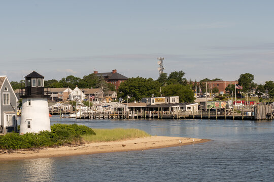 Hyannis Port, Massachusetts-July 6, 2022: View of the charming Hyannis Port lighthouse and restaurants in the Hyannis Port harbor on a summer afternoon.