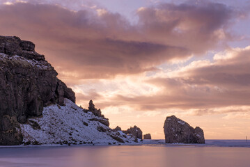 Early evening view as the sun is setting, of rocks on the coast of Iceland in the middle of  winter