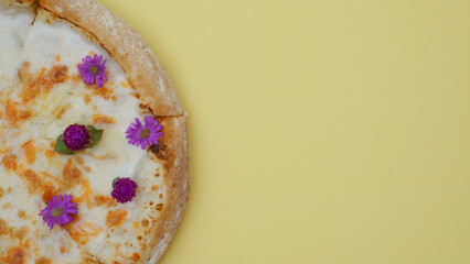 Delicious fresh pizza decorated with flowers sits on a monotone backdrop of close-up. minimalist concept in food, unusual food, serving, fun food 
