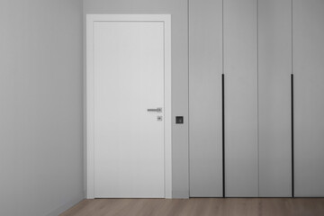 White door on the background of an empty gray wall
