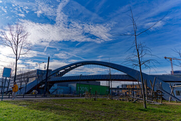 Tramway with tracks of tram line four and modern foot bridge in the background at City of Zürich on a blue cloudy winter day. Photo taken January 2nd, 2023, Zurich, Switzerland.