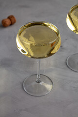 Sparkling Champagne in a Coupe Glass on a gray background, side view.