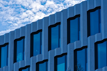 Obraz premium Close-up of pattern of modern facade of office building at City of Zürich on a blue cloudy day. Photo taken January 2nd, 2023, Zurich, Switzerland.