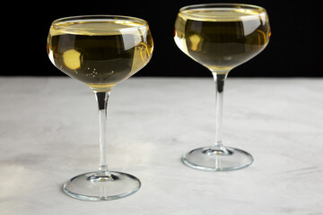 Sparkling Champagne in a Coupe Glass on a gray background, side view. Close-up.