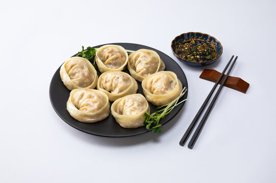 Delicious homemade Korean kimchi dumplings and sauce, white background