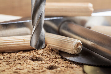 drill bit makes hole in wooden oak board for wooden dowel.