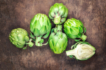 Artichoke flower buds. Fresh and raw artichoke on the wooden table. Copyspace. Top view.