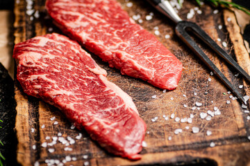 Raw steak with fork on the table. 