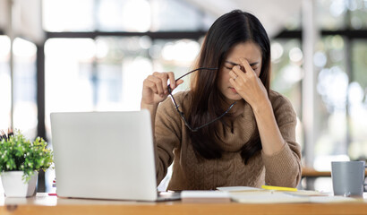 Tired Young freelance asian business woman with headache at office, feeling sick at work, Sad, unhappy, Worried, Depression, or employee life stress concept.